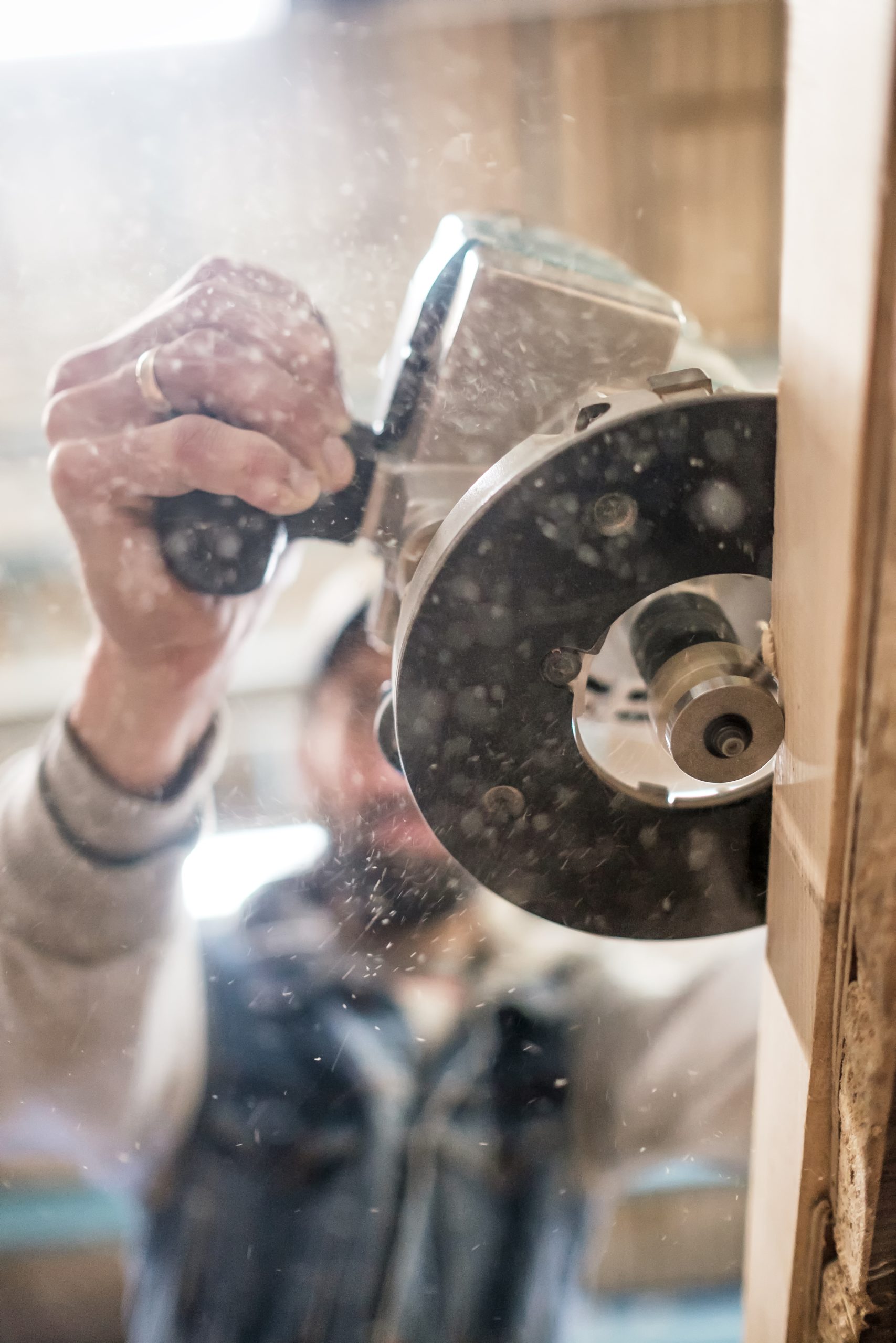 Carpenter using electric woodworking. Routing is a high speed process of cutting, trimming, and shaping wood
